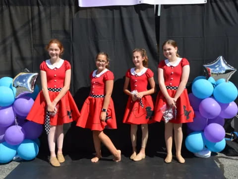 a group of women in red dresses