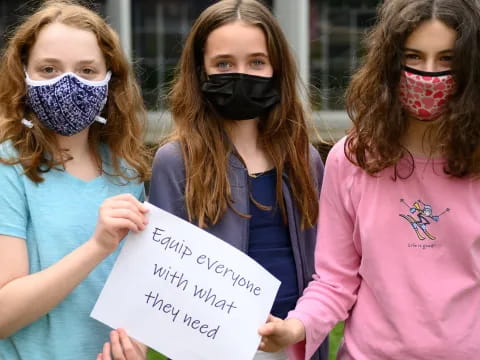 a group of women with face paint holding a sign