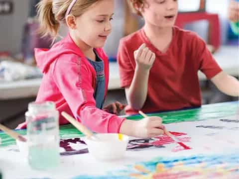 a couple of children painting