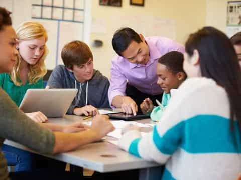 a group of people looking at a laptop