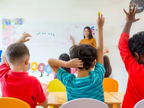 a group of children raising their hands