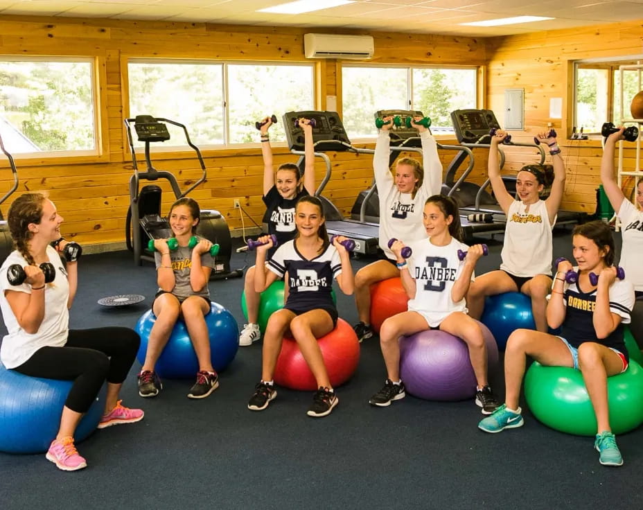 a group of people sitting on exercise balls in a gym