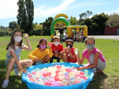 a group of kids posing for a picture with a ball pit