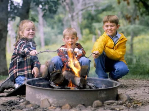 a group of children sitting in a fire pit