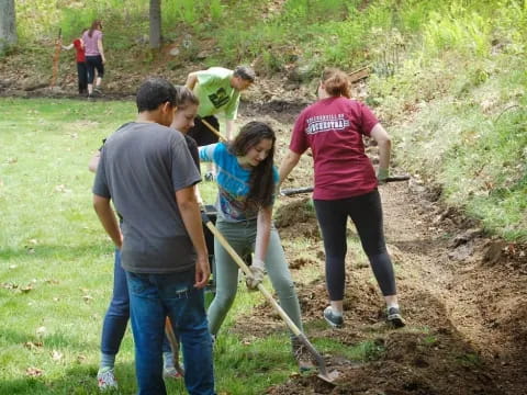 a group of people digging in the dirt