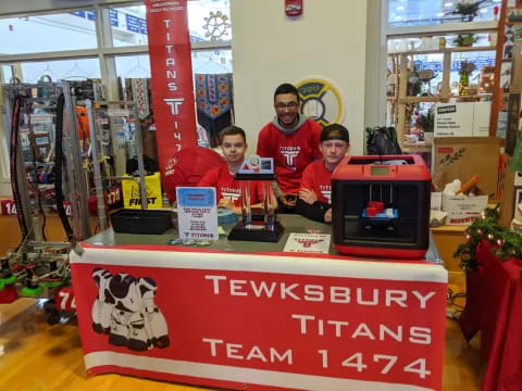 a group of men standing behind a table with a computer