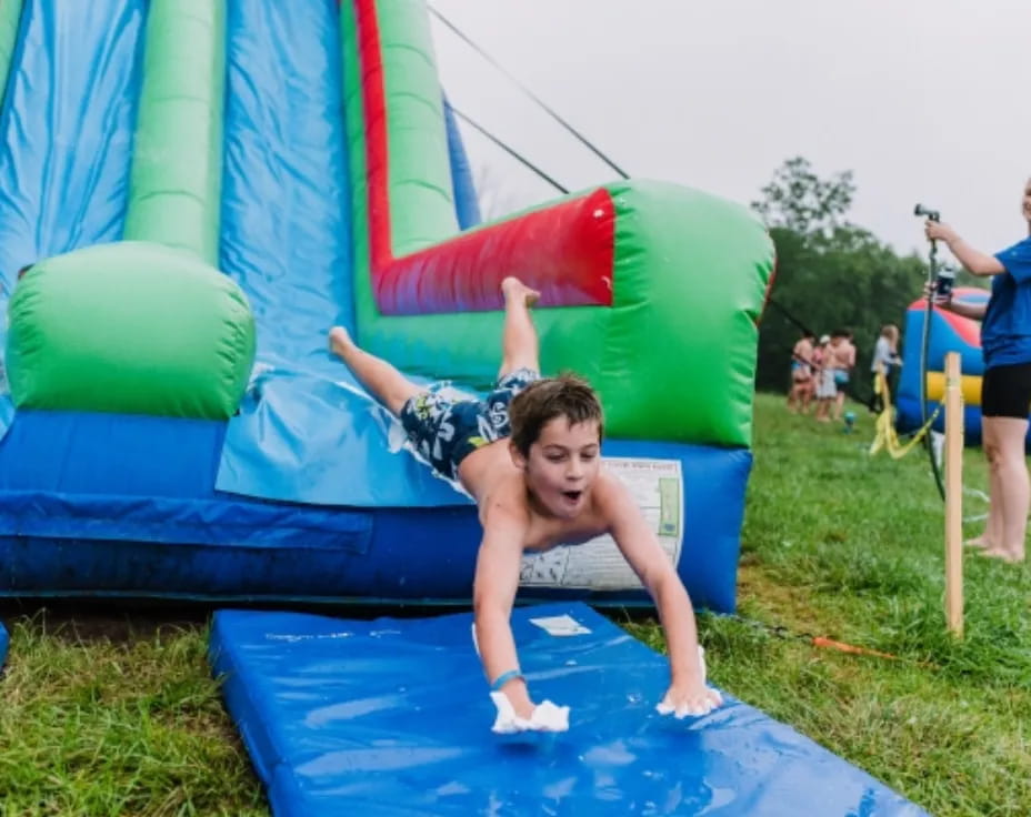 a person lying on a large green and blue slide