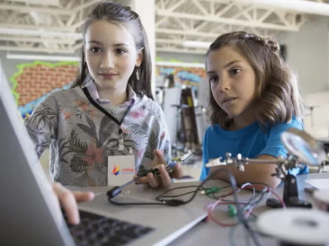 a few young girls working on their laptops