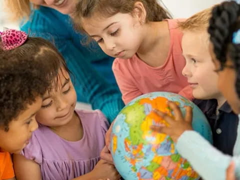 a group of children looking at a globe