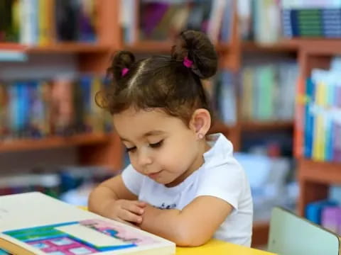 a young girl reading a book