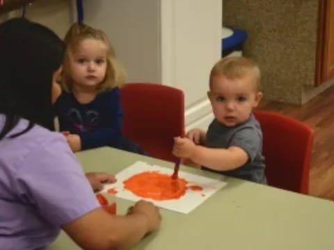 a person and a couple of children eating pizza