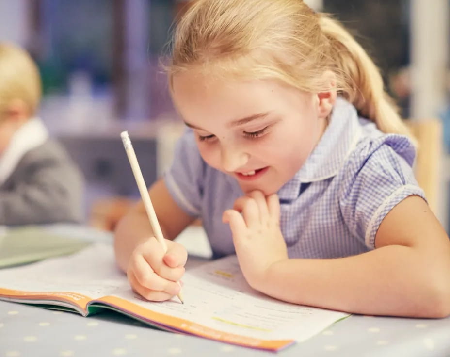 a young girl writing on a book