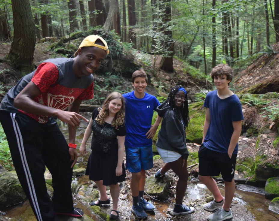 a group of people posing for a photo in the woods