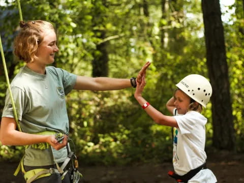 a man and a child on a swing in the woods