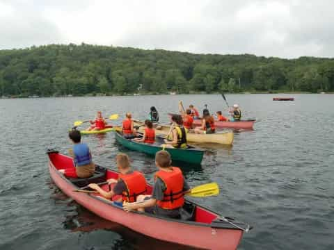 a group of people in canoes on a lake