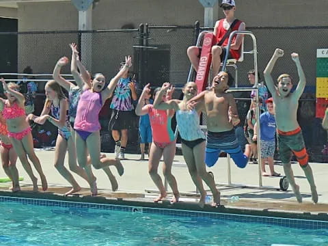 a group of people jumping into a pool
