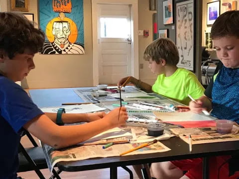 a group of boys sitting at a table with a drawing on it