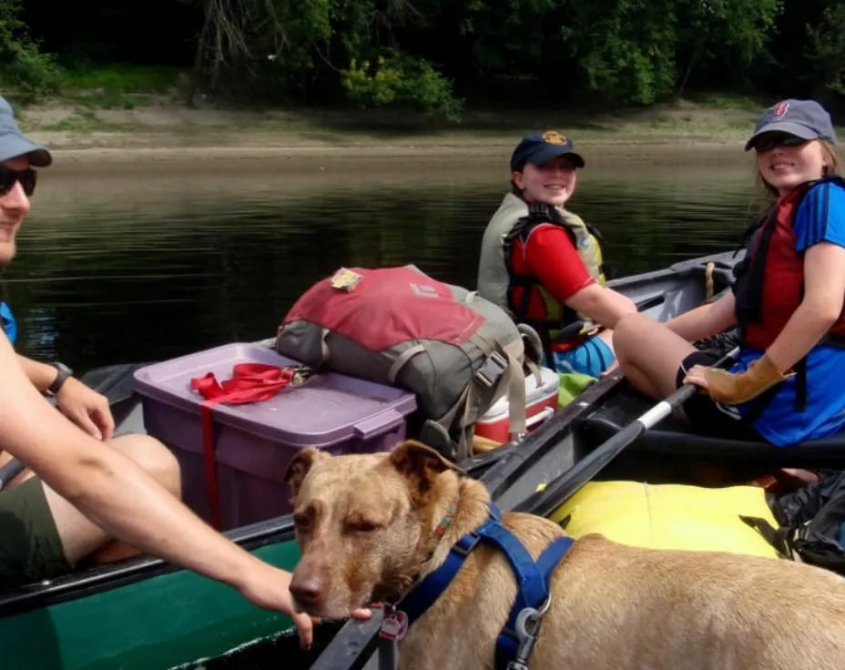 a group of people in a boat with a dog