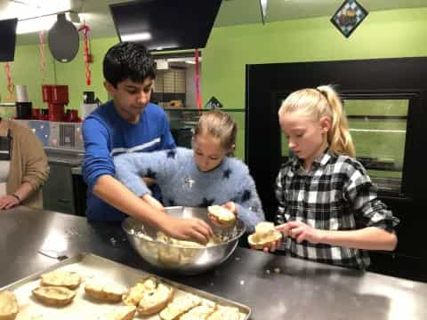 a group of kids making sandwiches