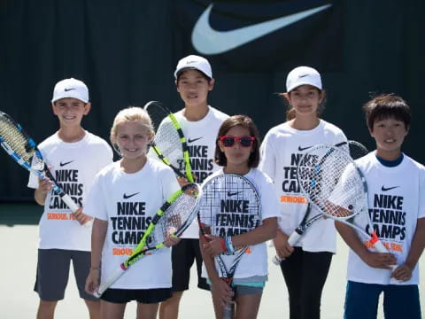 a group of kids holding tennis rackets