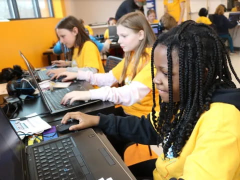 a group of girls using laptops