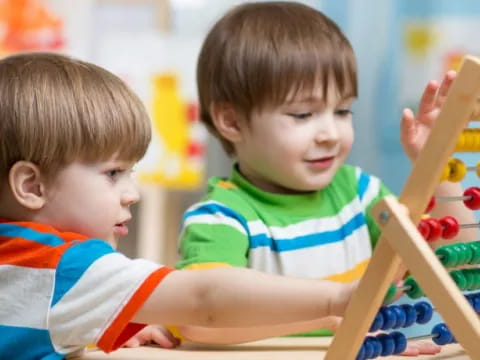 a couple of boys playing on a playground toy