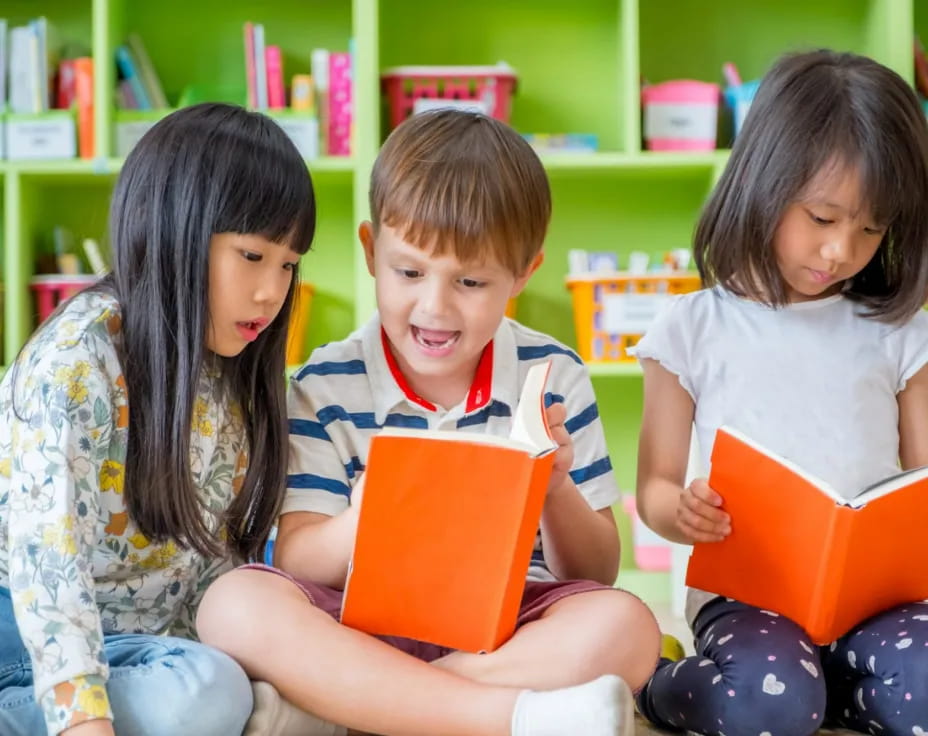 a group of children sitting on the floor reading books