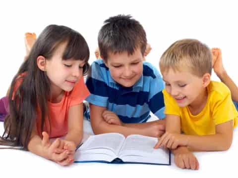 a group of children reading a book