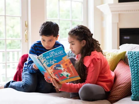 a boy and girl reading a book