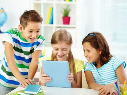 a group of children looking at a tablet