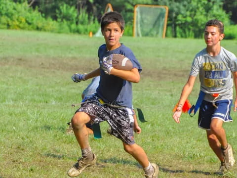 a couple of boys running on a field