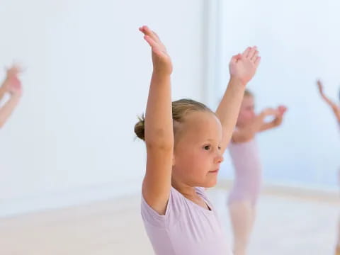 a group of children raising their hands