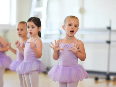 a group of girls in dresses dancing