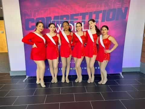 a group of women in red dresses