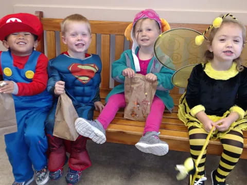 a group of children sitting on a bench