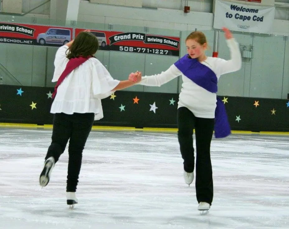 a couple of women ice skating