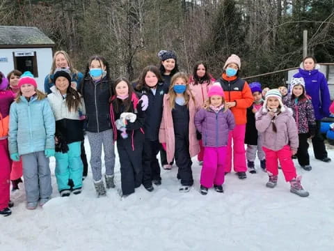 a group of people posing for a photo in the snow