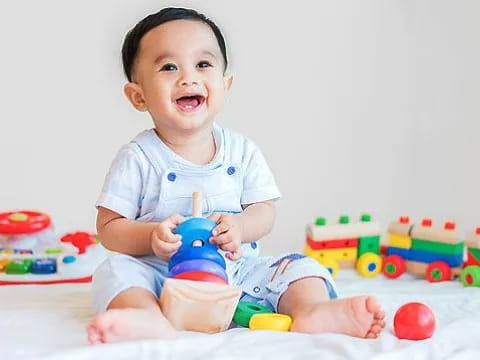 a baby sitting on the floor with toys