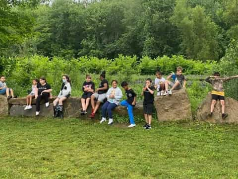 a group of people sitting on a rock