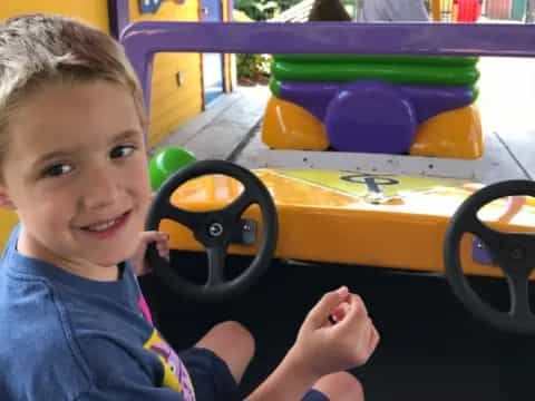 a boy sitting in a toy car