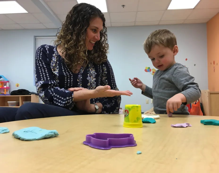 a person and a child playing with toys on a table