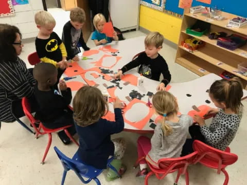 a group of children sitting around a table