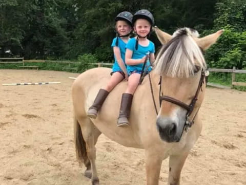 a couple of girls riding a horse