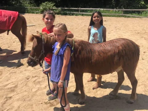 a group of children standing next to a couple of horses