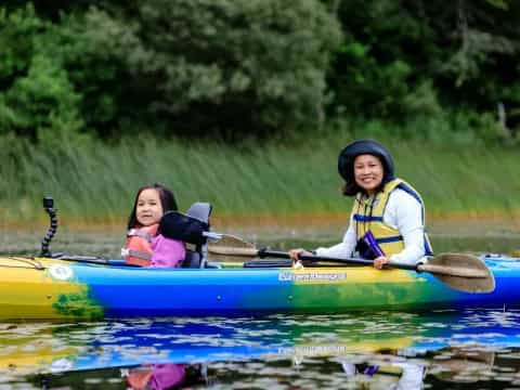 a person and a girl in a canoe on a lake