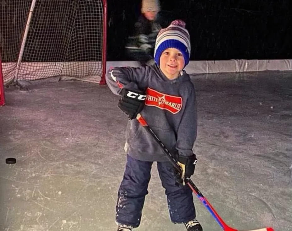 a boy wearing a hockey uniform and holding a hockey stick