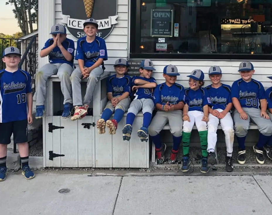 a group of people wearing matching blue uniforms sitting on a bench