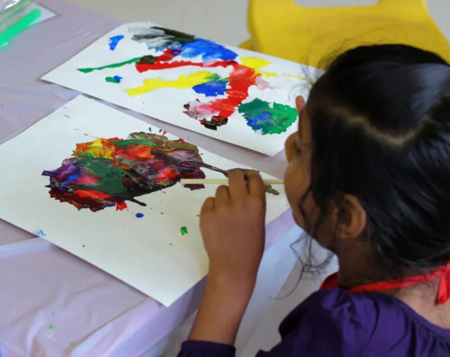 a child painting on a white board