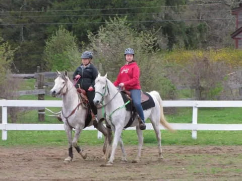 a couple of people riding horses