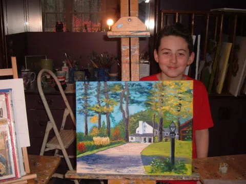 a boy holding a painting